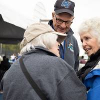 Two alumni talk to Marcia Haas at the Alumni Homecoming Tailgate.